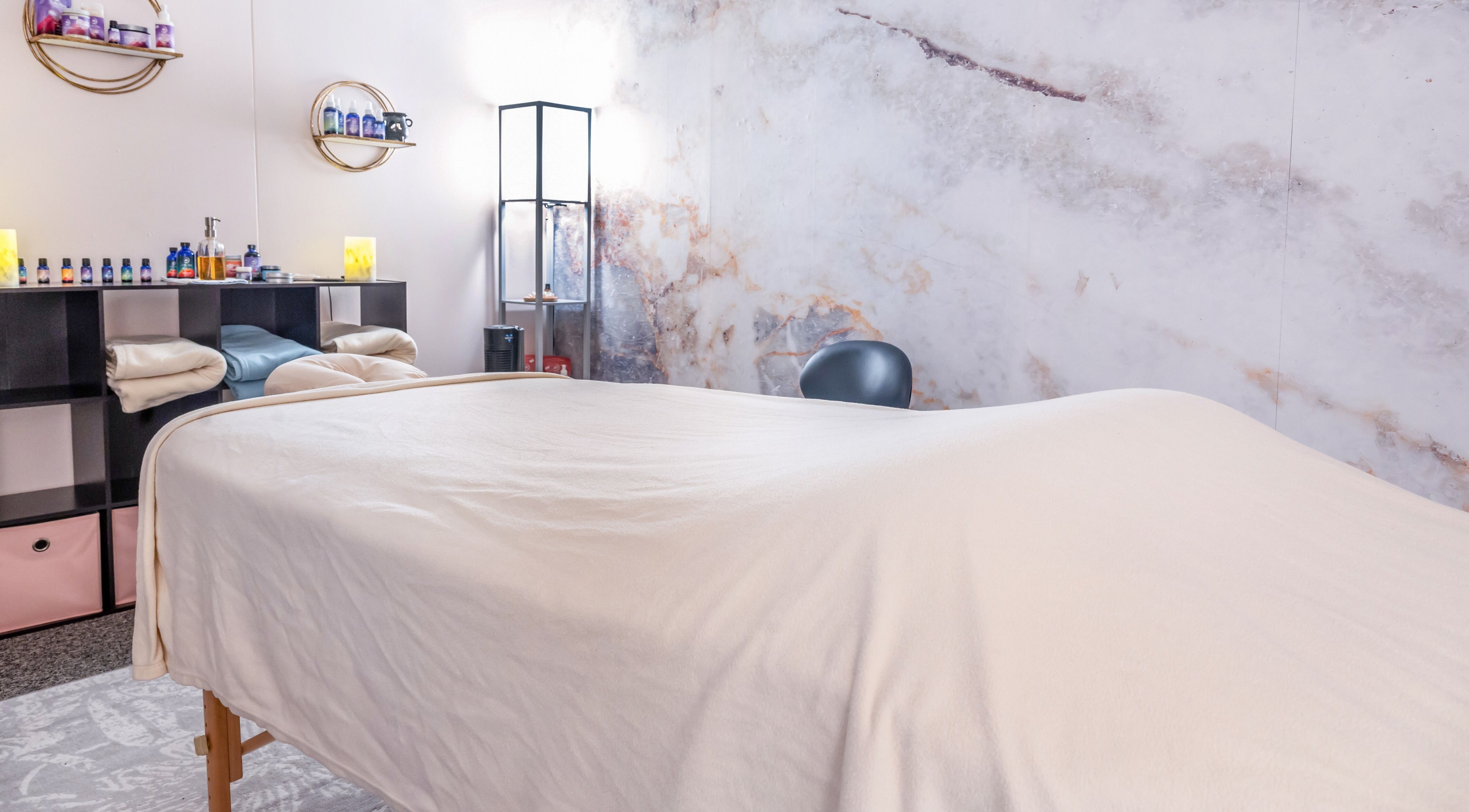 Calming spa room at Open Your Heart, Saline, Michigan, US with massage table and essential oils.