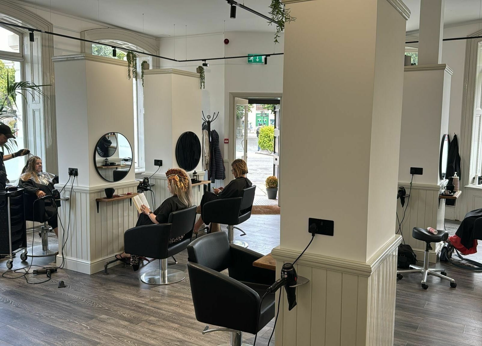 Bright, spacious salon interior at David & David, Plymouth, England, GB, with clients and stylists in action.
