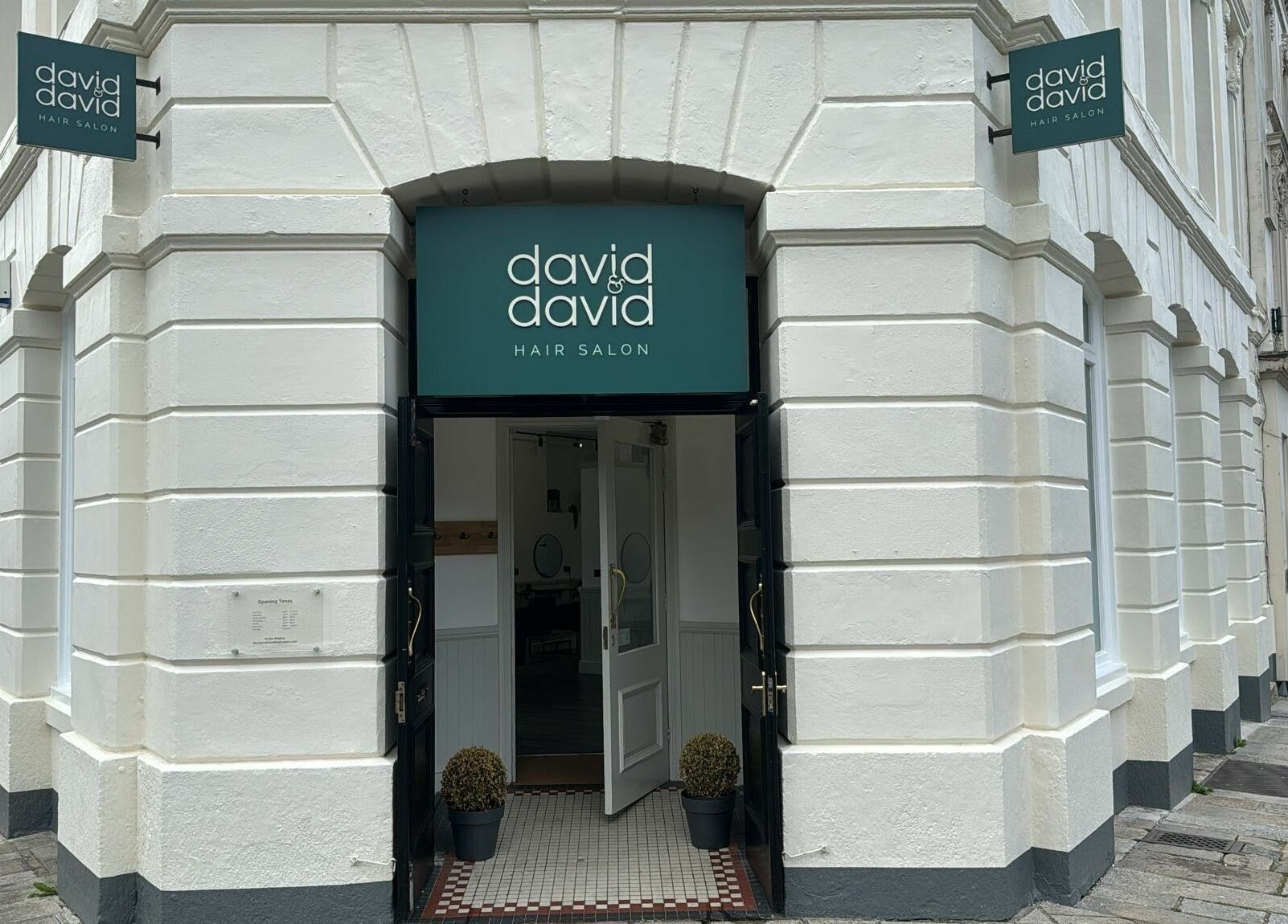 David & David hair salon entrance in Plymouth, England, GB, showcasing elegant white exterior with open door.