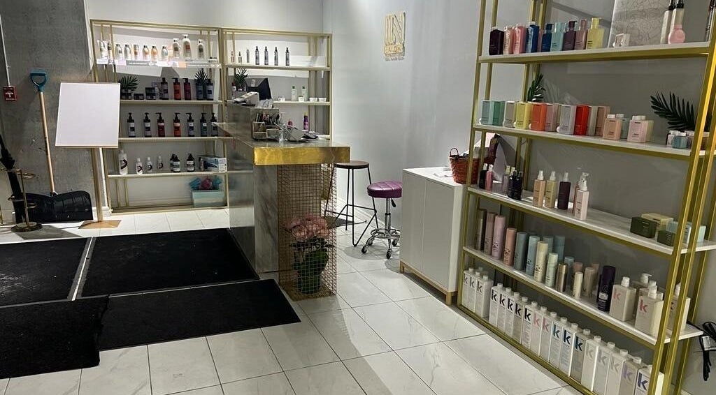 Reception area of SK Hair Salon in Montréal, Québec, CA, showcasing modern design with shelves of beauty products.