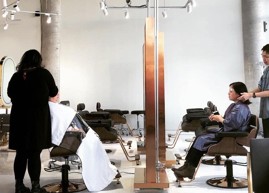 Stylists working with clients at SK Hair Salon, Montréal, Québec, CA, showcasing a modern and elegant interior.