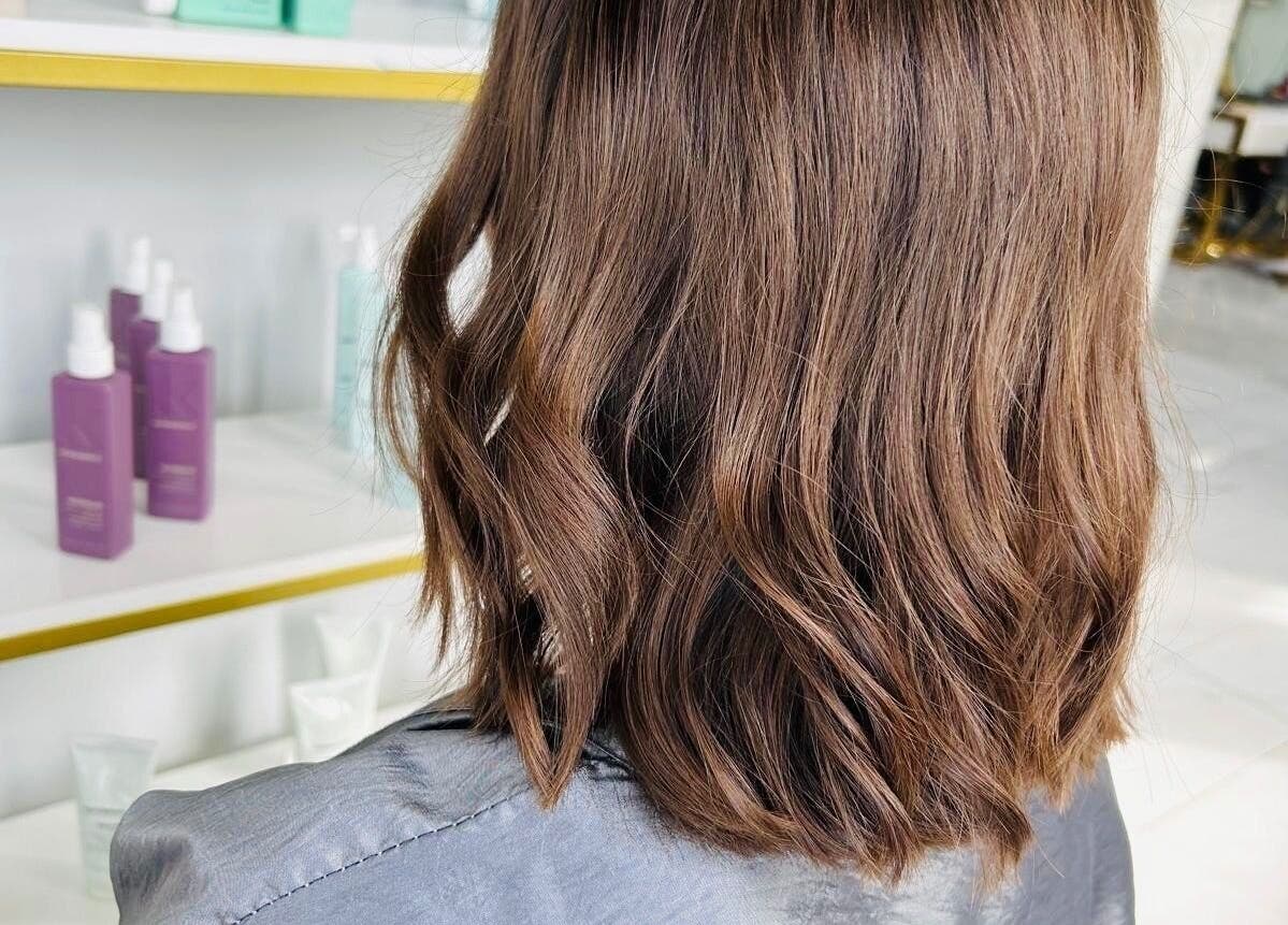 Stylish brown wavy hair at SK Hair Salon in Montréal, Québec, CA showcasing premium haircare products.