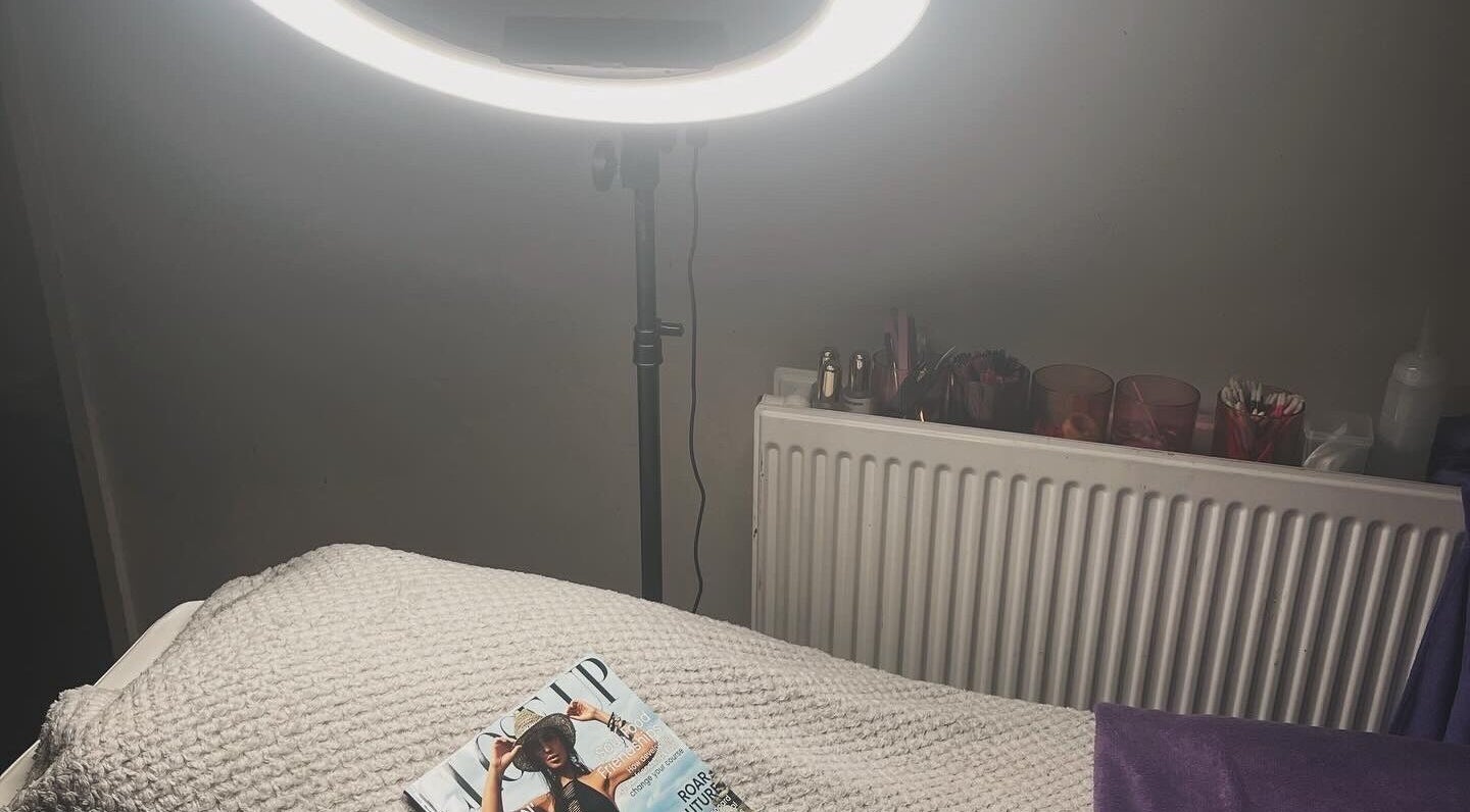 Peaceful treatment room at Aura Lounge Aesthetics, London, England, GB, featuring a cozy bed and ring light.
