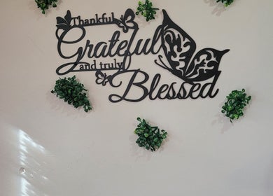 Decorative wall art at Dee Smith Beauty Experts, Couva, TT reads 'Thankful, Grateful, Blessed' with greenery accents.