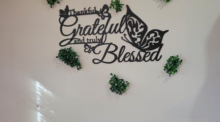 Decorative wall art at Dee Smith Beauty Experts, Couva, TT reads 'Thankful, Grateful, Blessed' with greenery accents.