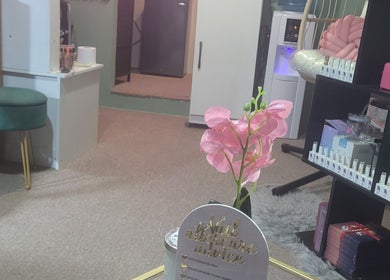 Cozy interior of Dee Smith Beauty Experts in Couva with pink floral decor and organized shelves.