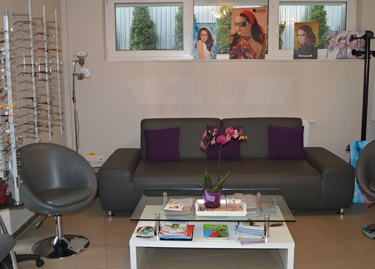 Zona de așteptare confortabilă la Oftaconsult Cluj, Cluj-Napoca, Județul Cluj, RO, cu canapea și ochelari expuși.