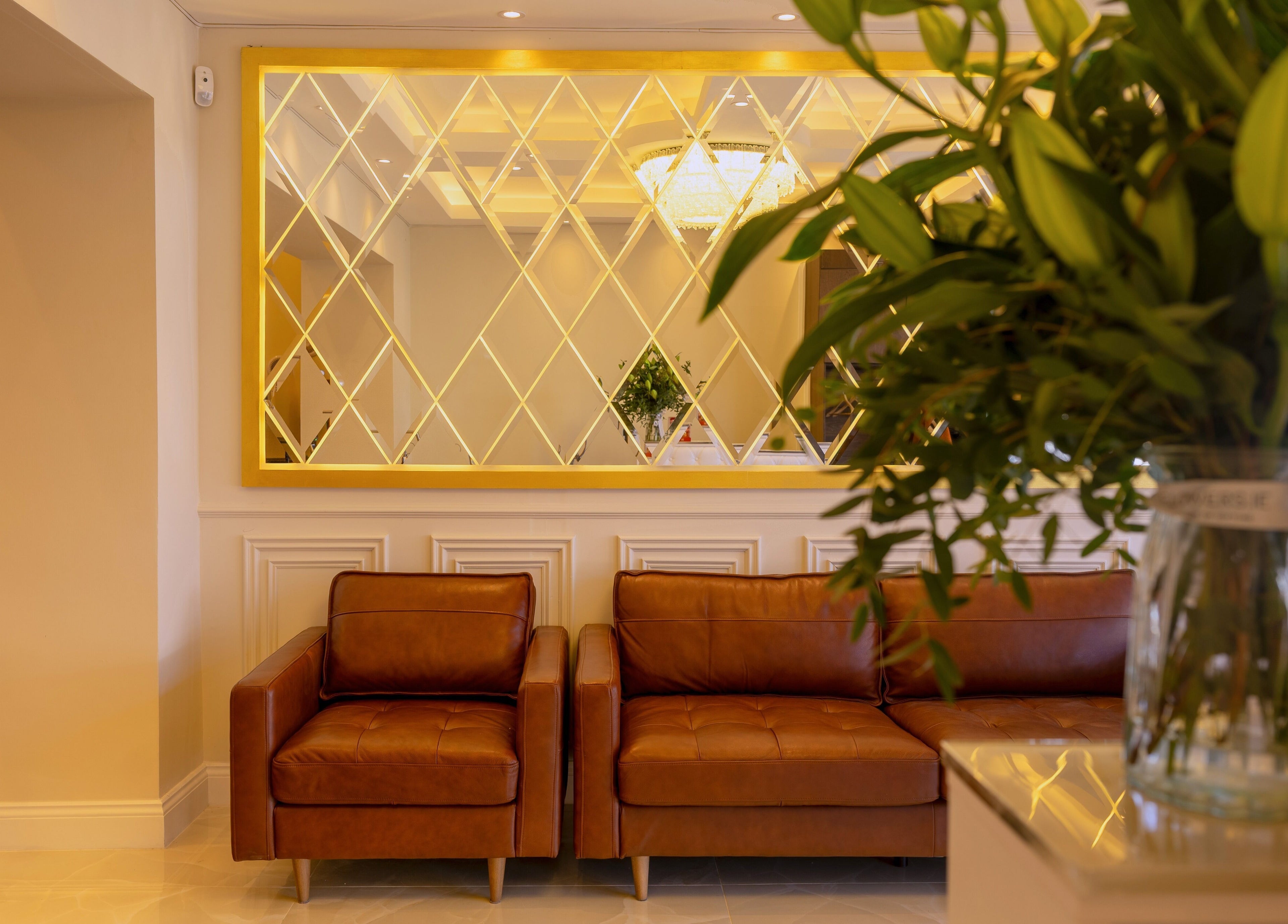 Elegant seating area at Dolce Nails Naas, Naas, IE with plush sofas and decorative mirror.