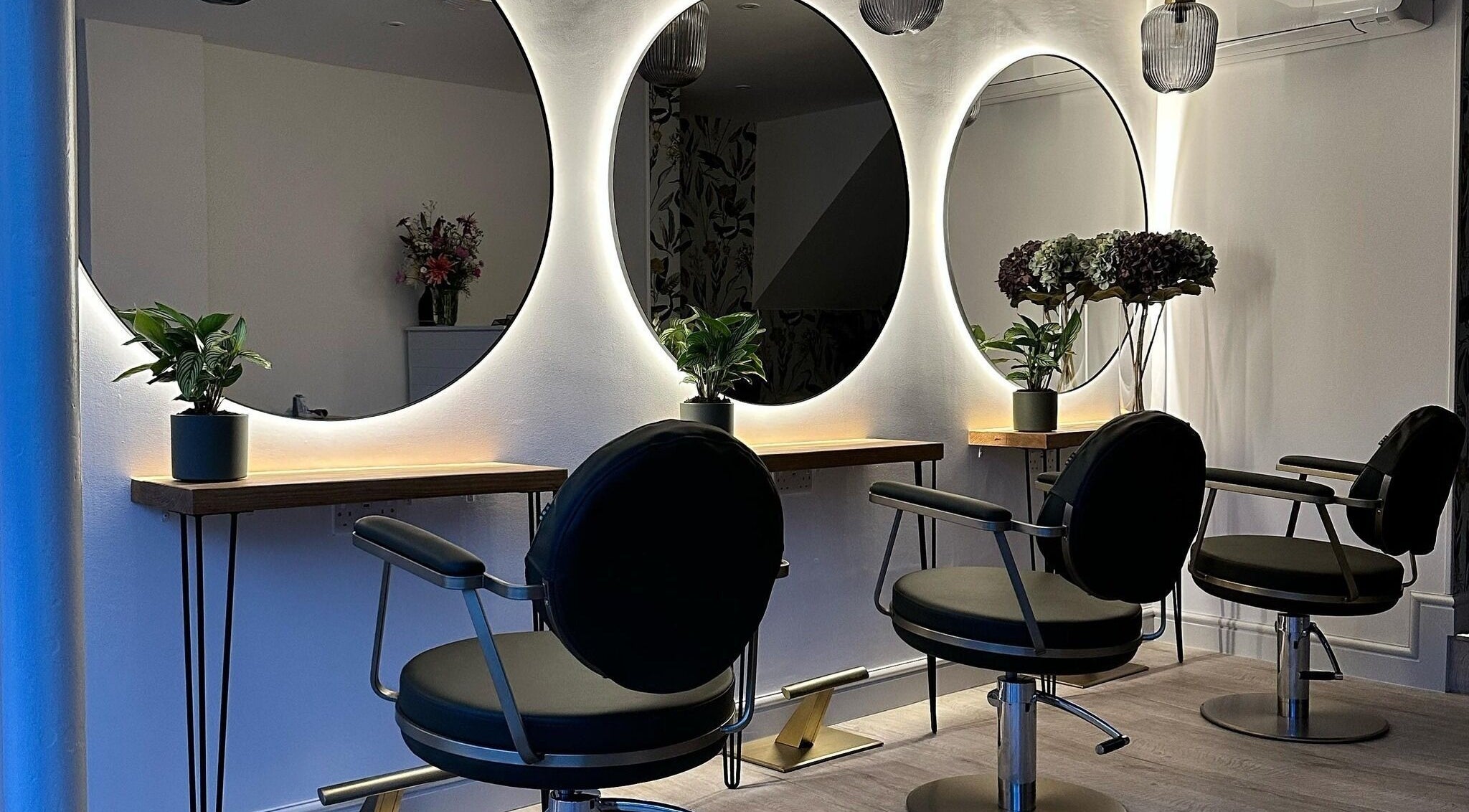 Sleek styling chairs and illuminated mirrors at BOUDICA Hair And Beauty, Mountsorrel, England, GB.