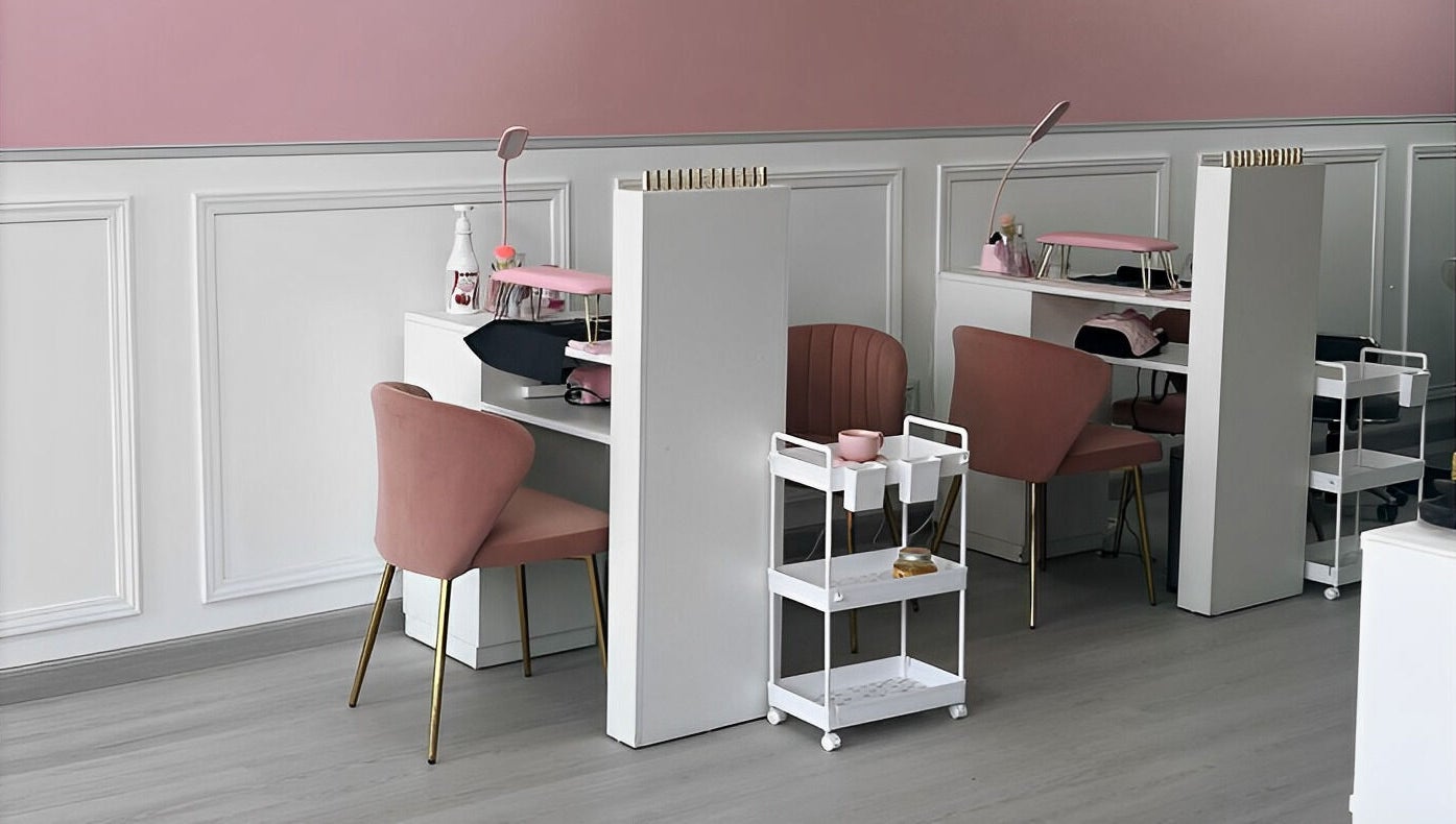 Interior moderno de DTA Nails en Tijuana, Baja California, MX, con sillas rosas y mesas de manicura.