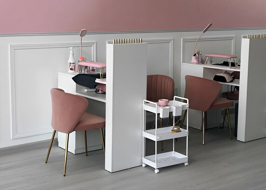 Interior moderno de DTA Nails en Tijuana, Baja California, MX, con sillas rosas y mesas de manicura.