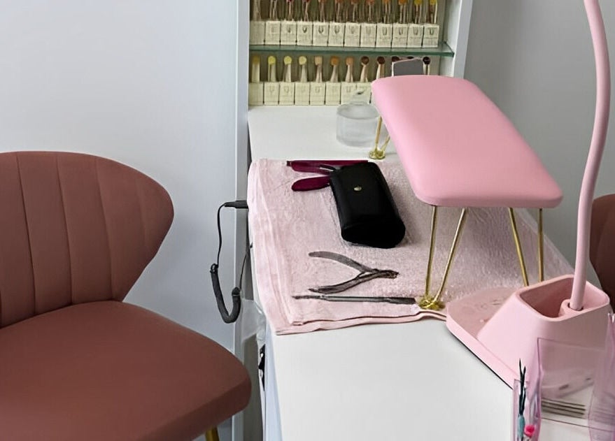 Estación de manicura en DTA Nails, Tijuana, Baja California, MX con silla y lámpara rosa.