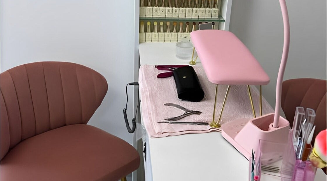 Estación de manicura en DTA Nails, Tijuana, Baja California, MX con silla y lámpara rosa.