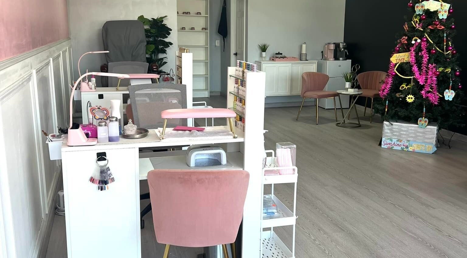 Interior de DTA Nails en Tijuana, Baja California, MX decorado con árbol de Navidad y mobiliario elegante.