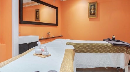 Tranquil massage room at Eleven Thai Therapy, London, England, GB with warm tones and elegant decor.