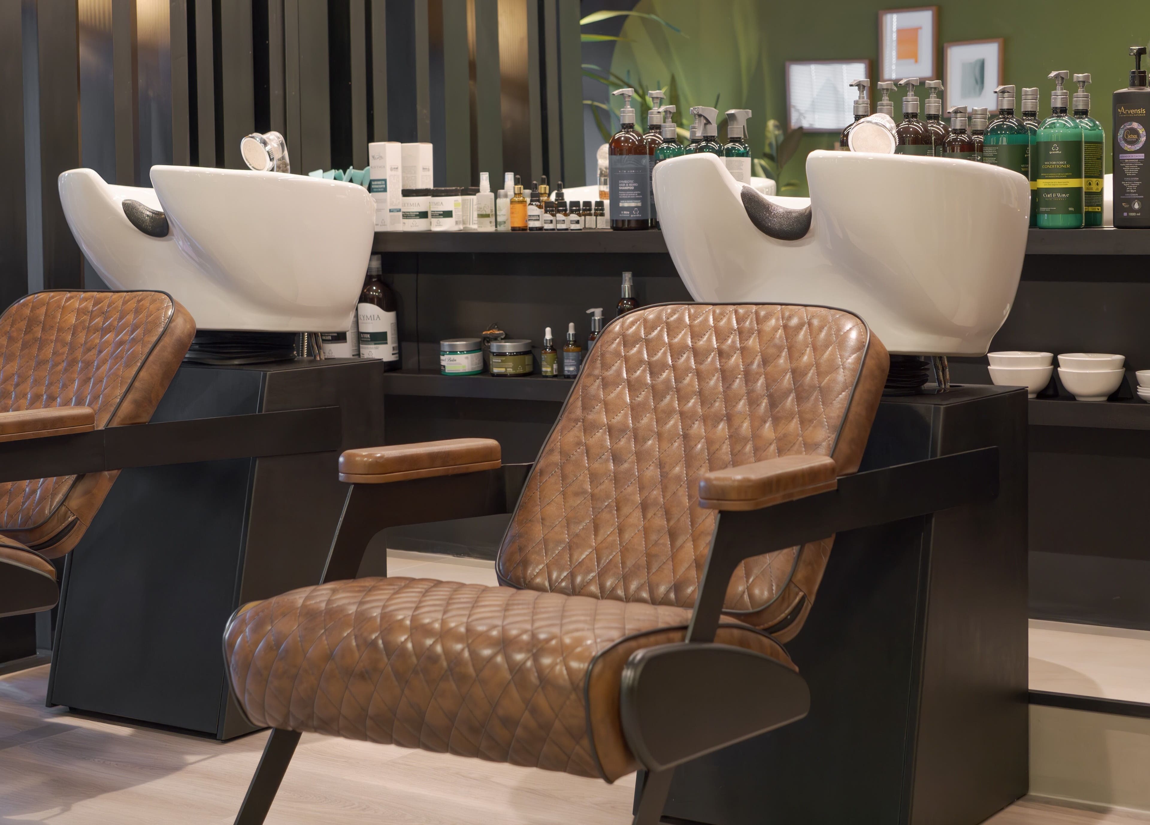 Interior moderno da Carol Scavello Barbearia com poltronas de couro em Bahia, Bahia, BR.