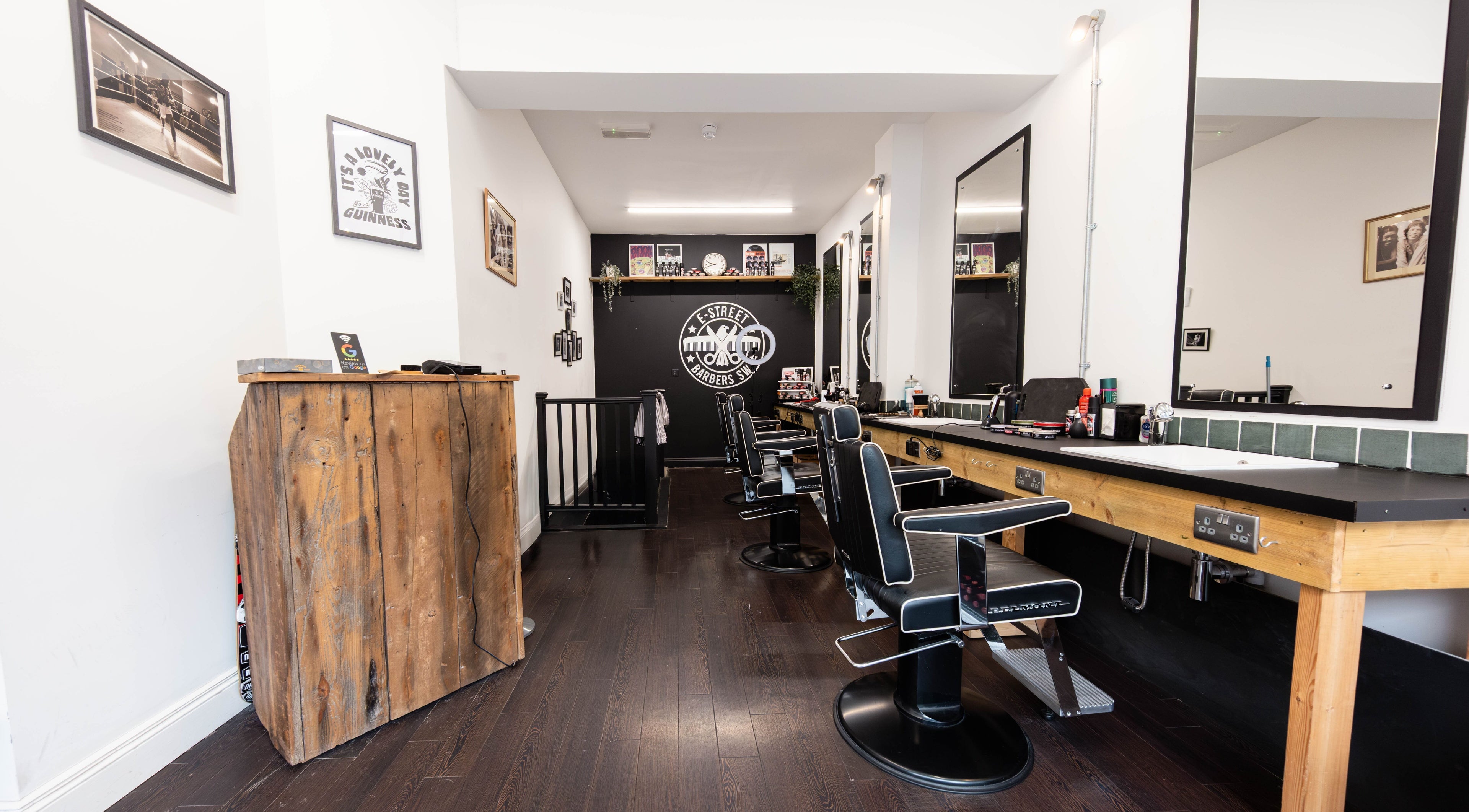 Modern barber chairs in E-Street Barbers SW, London, England, GB, featuring stylish decor.