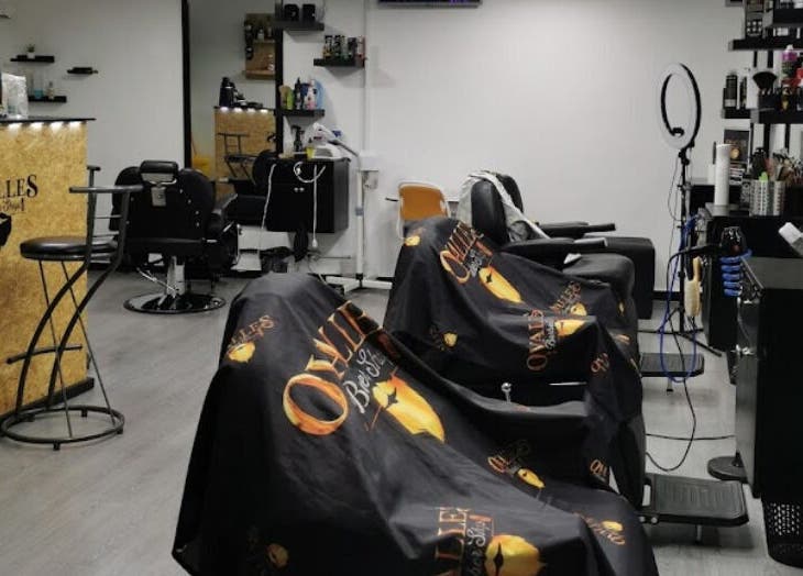 Interior moderno de Ovalles Barber Shop en Santo Domingo, Distrito Nacional, DO, mostrando sillas y espejos.