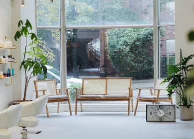 Relaxing seating at Salon Esprit, Vancouver, British Columbia, CA with stylish decor and large windows.