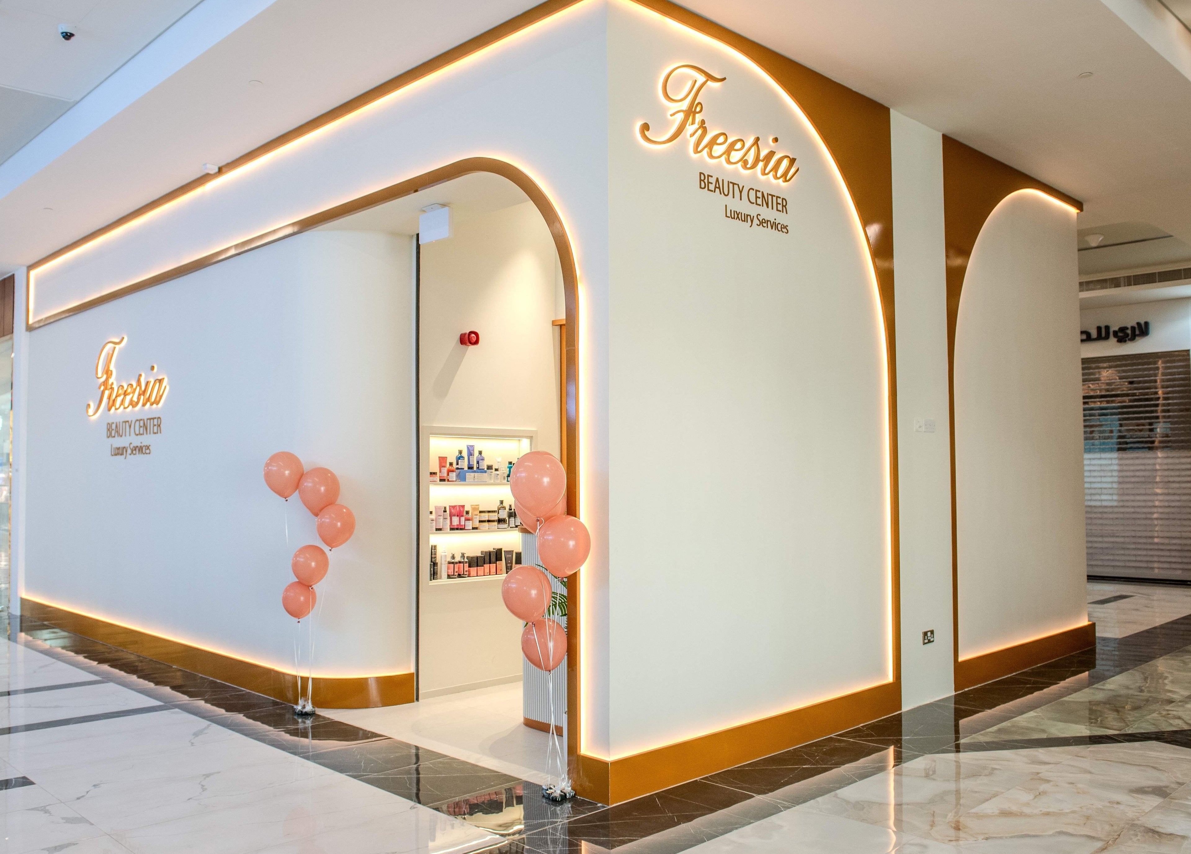 Freesia Beauty Center entrance in Shawamekh Central Mall, Abu Dhabi, features elegant design with peach balloons.