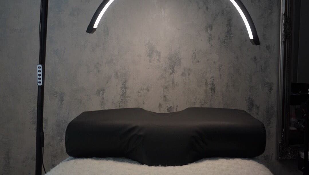 Modern treatment room at AJade Cosmetics, Birmingham, England, GB, featuring sleek lighting and a plush treatment bed.