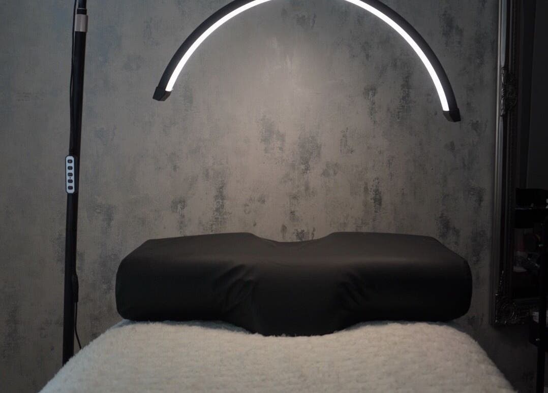 Modern treatment room at AJade Cosmetics, Birmingham, England, GB, featuring sleek lighting and a plush treatment bed.