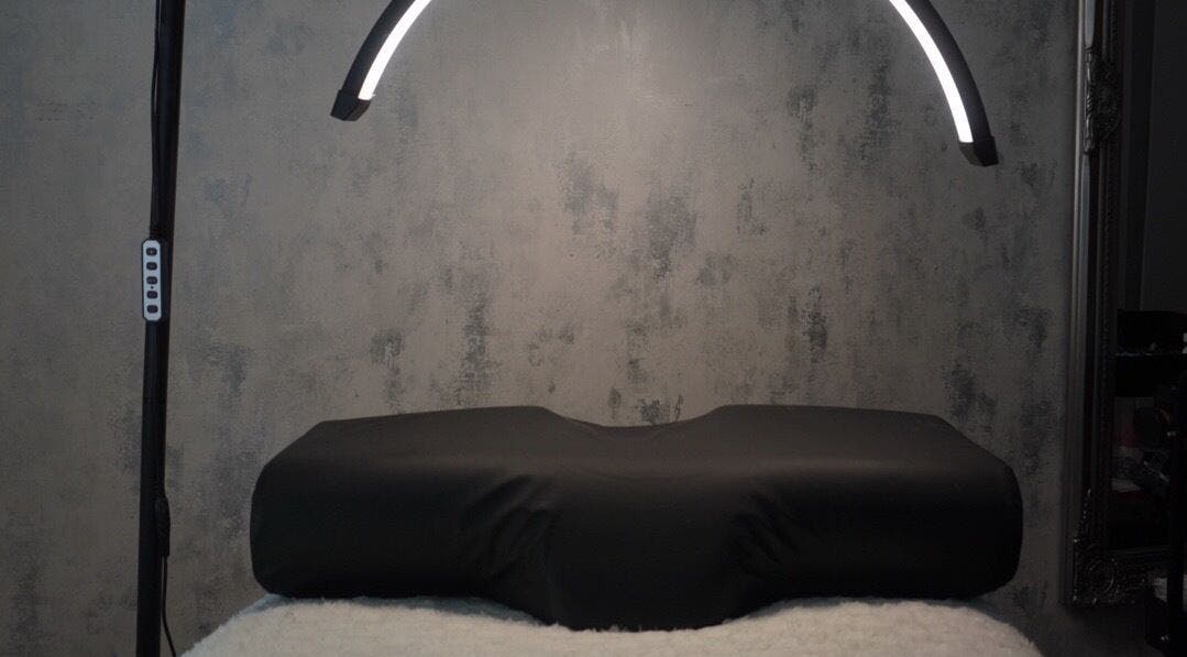 Modern treatment room at AJade Cosmetics, Birmingham, England, GB, featuring sleek lighting and a plush treatment bed.