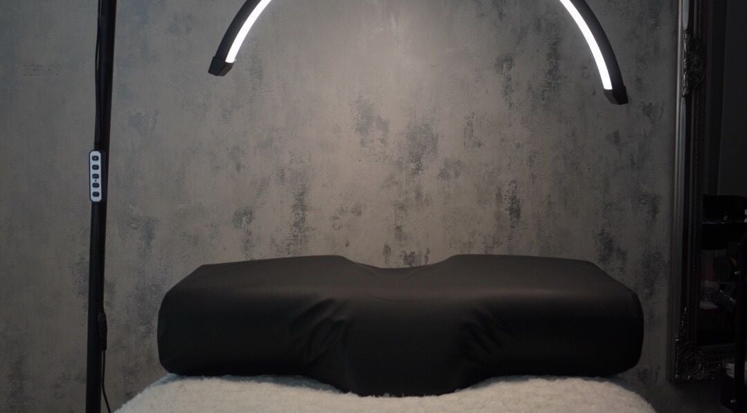 Modern treatment room at AJade Cosmetics, Birmingham, England, GB, featuring sleek lighting and a plush treatment bed.