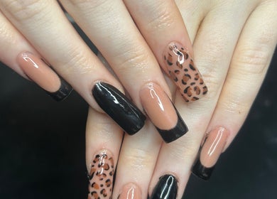 Chic nail design with black French tips and leopard print at The Beauty Bar, Drumoak, Scotland, GB.