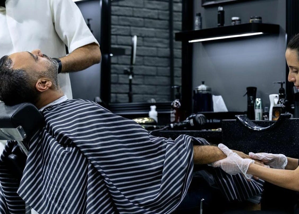 Barber and client in Style and Shine Gents, Dubai, AE. Relaxing grooming session with attention to detail.