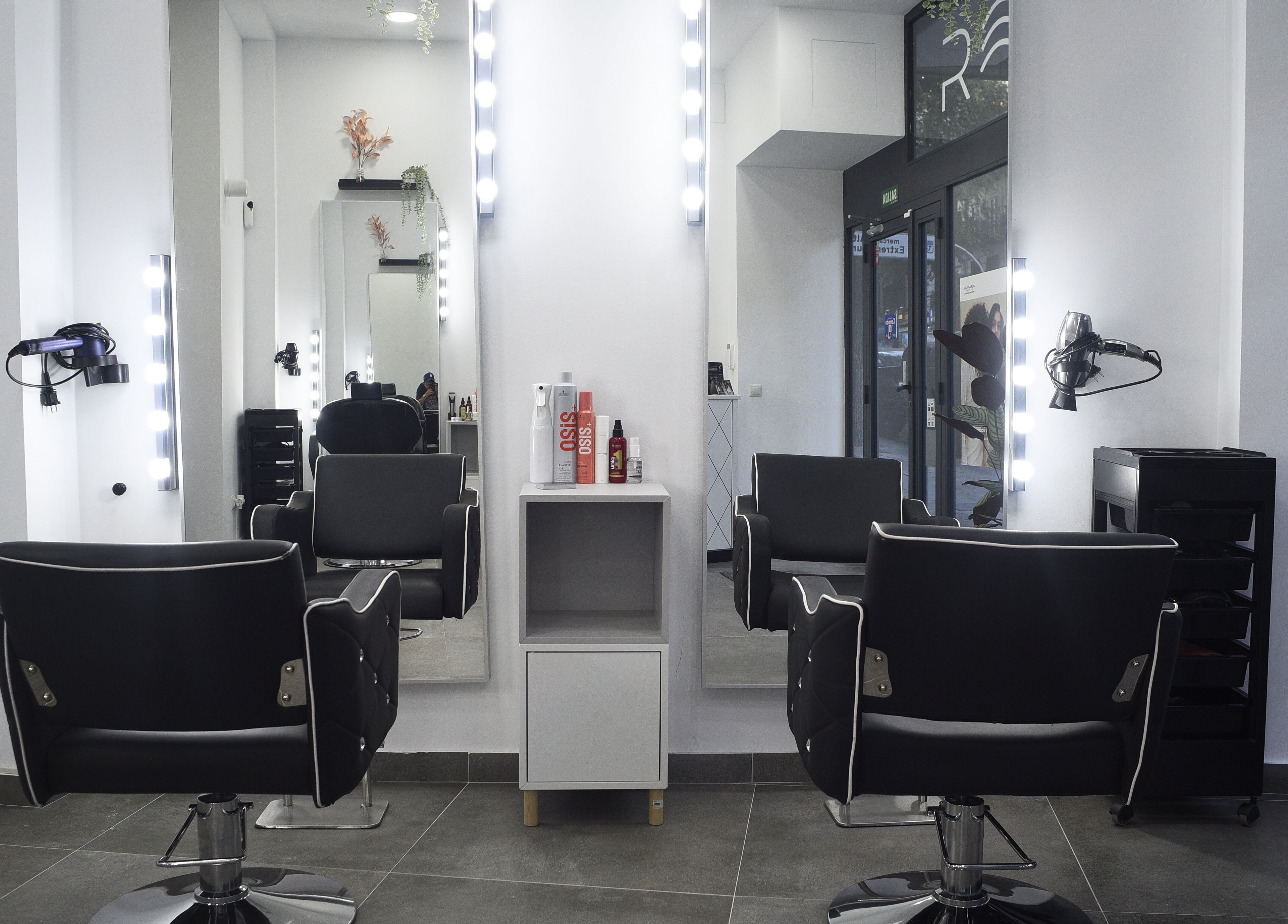 Interior de peluquería en Revive, Madrid, Comunidad De Madrid, ES, con elegantes sillas y espejos iluminados.