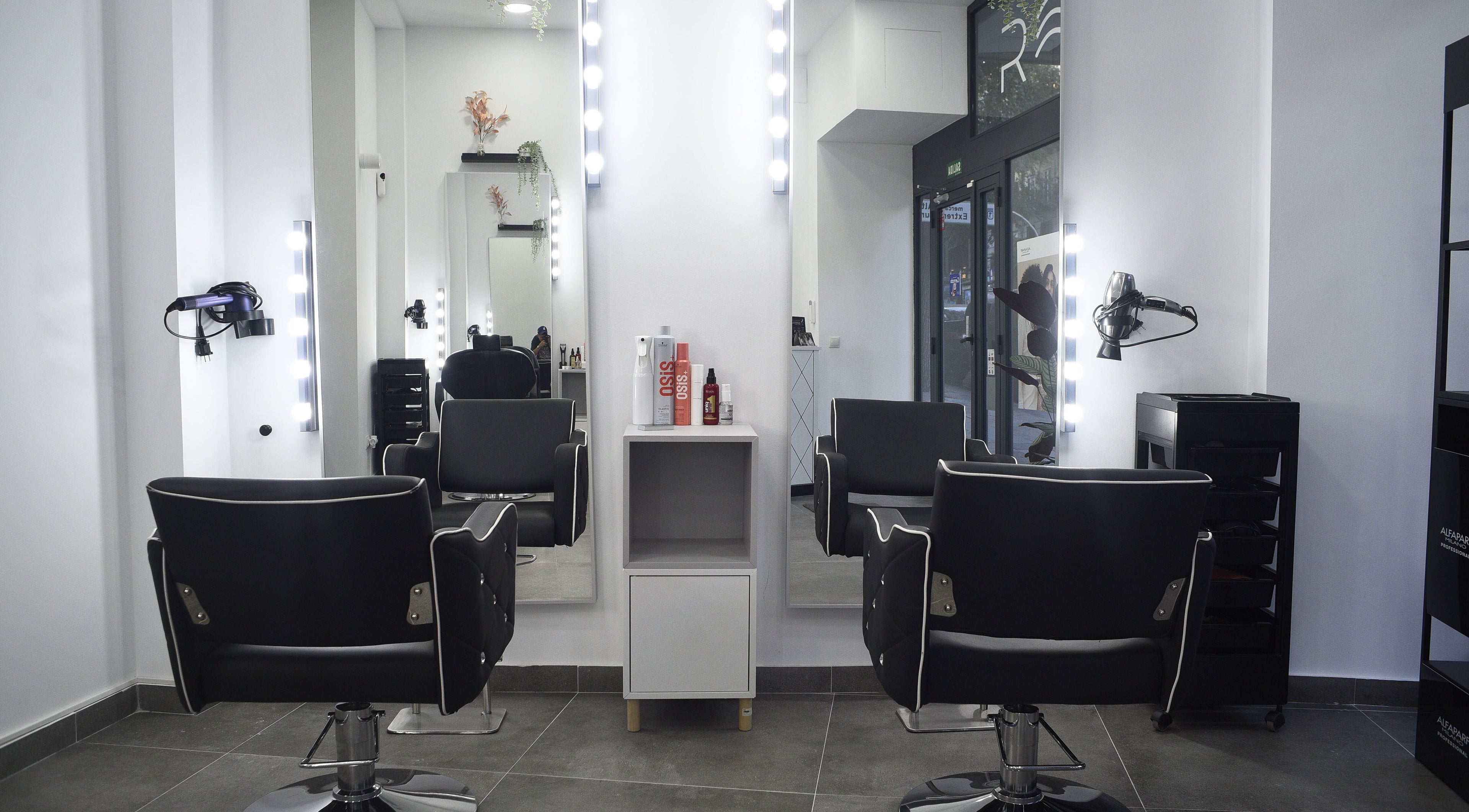 Interior de peluquería en Revive, Madrid, Comunidad De Madrid, ES, con elegantes sillas y espejos iluminados.