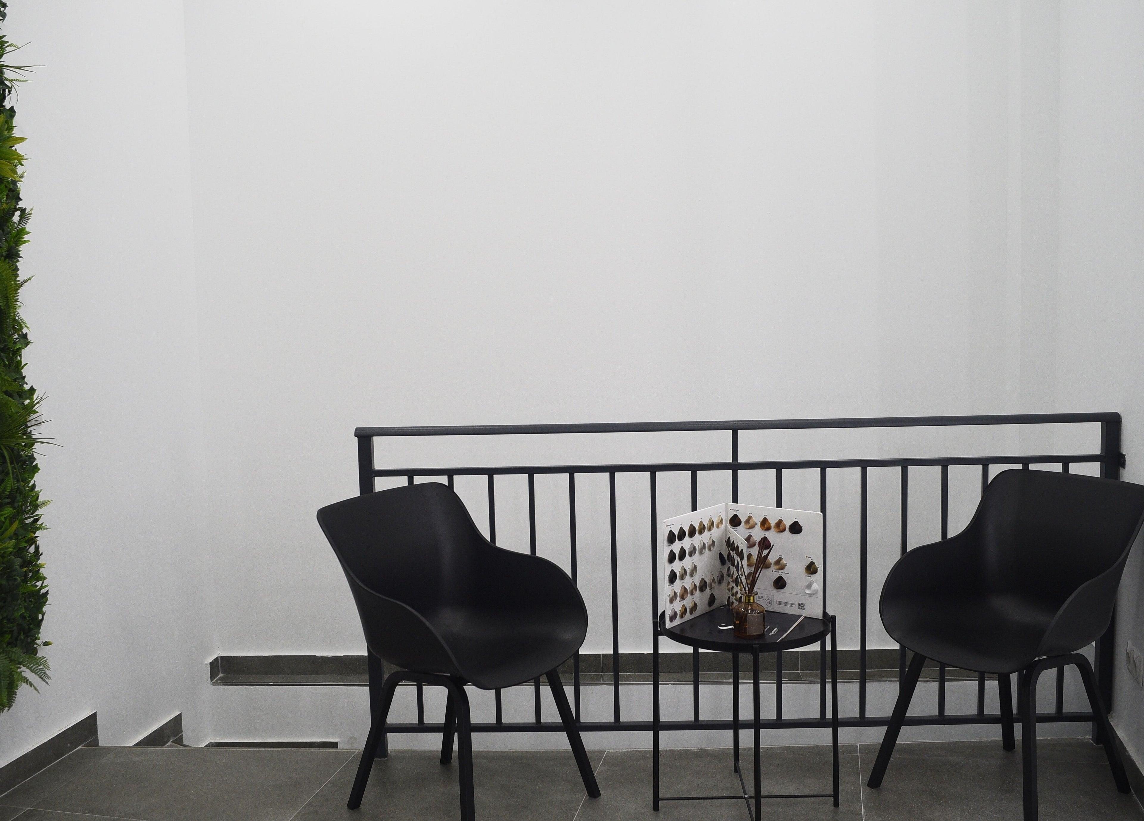 Zona de descanso en Revive, Madrid, Comunidad de Madrid, ES, con sillas modernas y pared vegetal.