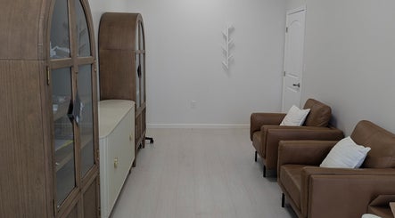Chic seating area at Identity Aesthetics, Katy, Texas with leather chairs and cabinets.