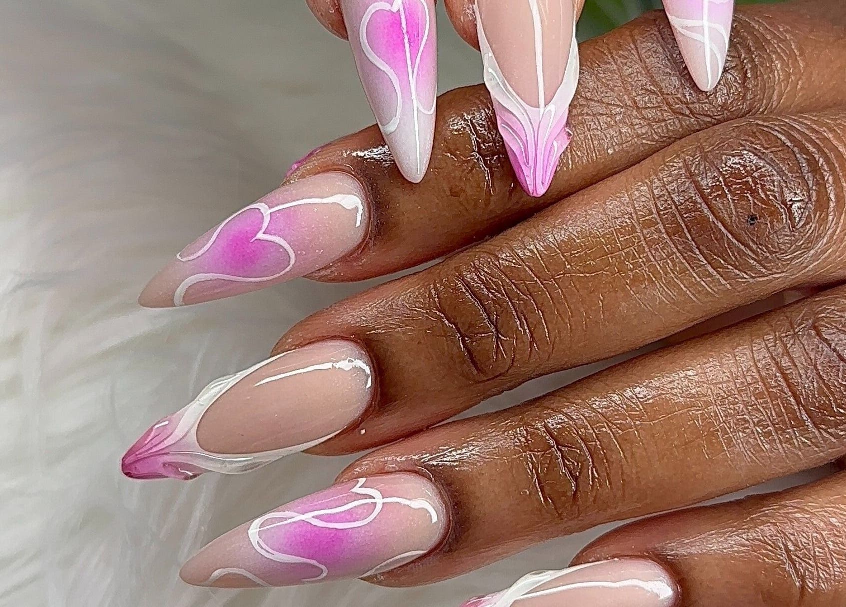 Intricate pink heart nail art at Angel Nails & Head Spa, Denton, Texas, US, showcasing unique nail designs.