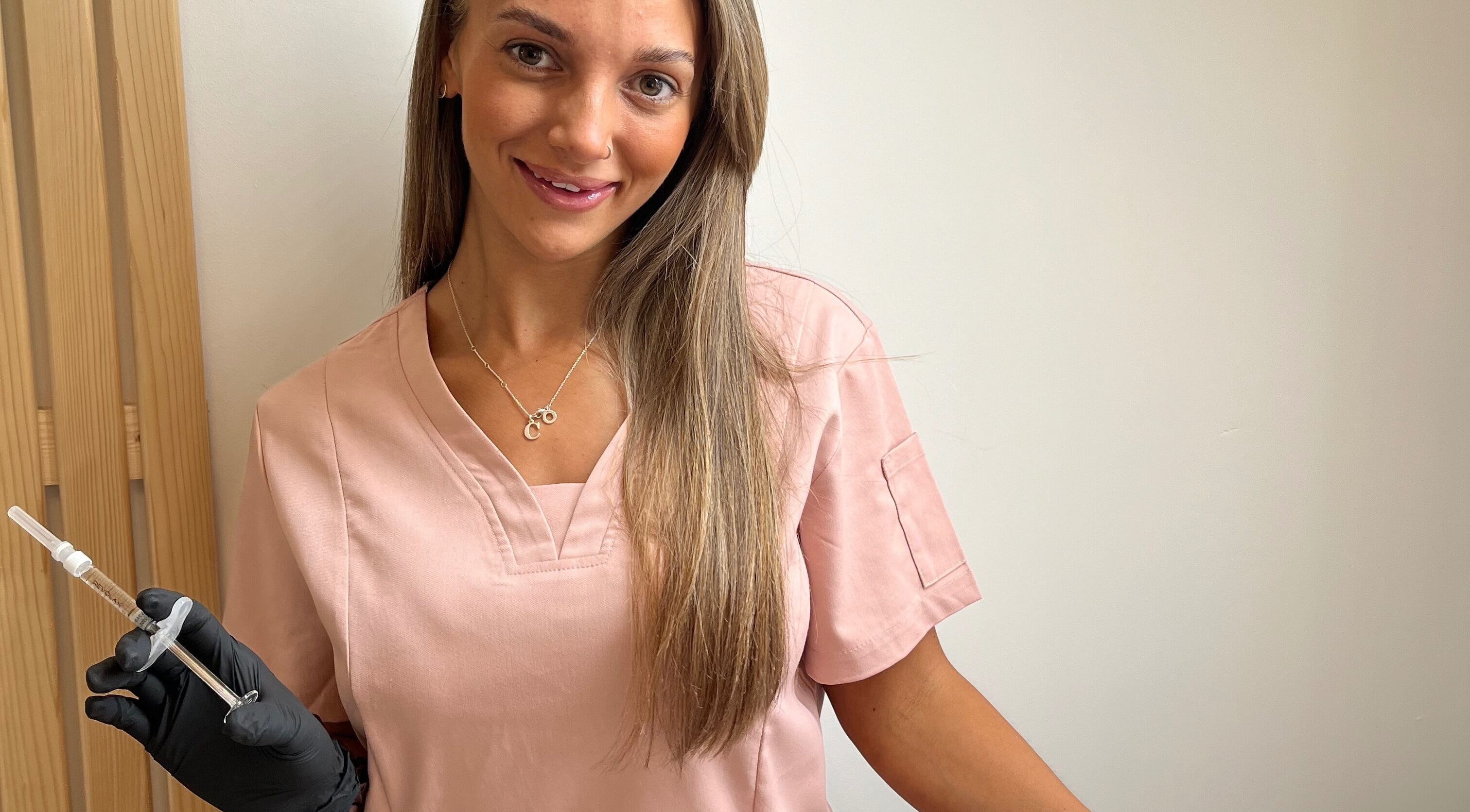 Aesthetician at Natural+ in Hapton, England, GB, holding a syringe, showcasing modern beauty treatments.