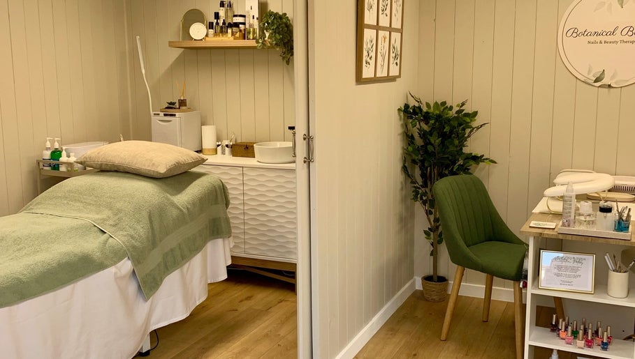Relaxing treatment room at Botanical Beauty in Swadlincote, England, GB, with soothing decor and plush green chair.
