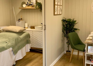 Relaxing treatment room at Botanical Beauty in Swadlincote, England, GB, with soothing decor and plush green chair.