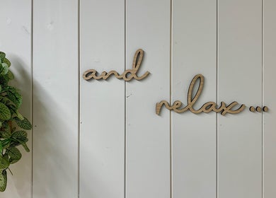 Wooden 'and relax' sign with green plant at Botanical Beauty, Swadlincote, England, GB.