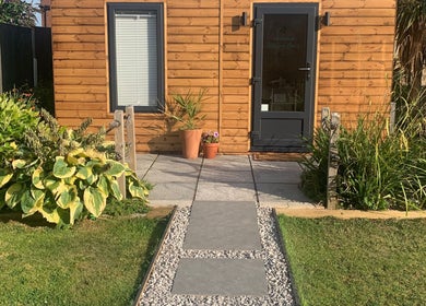 Entrance of Botanical Beauty in Swadlincote, England, GB, framed by lush greenery and wooden facade.