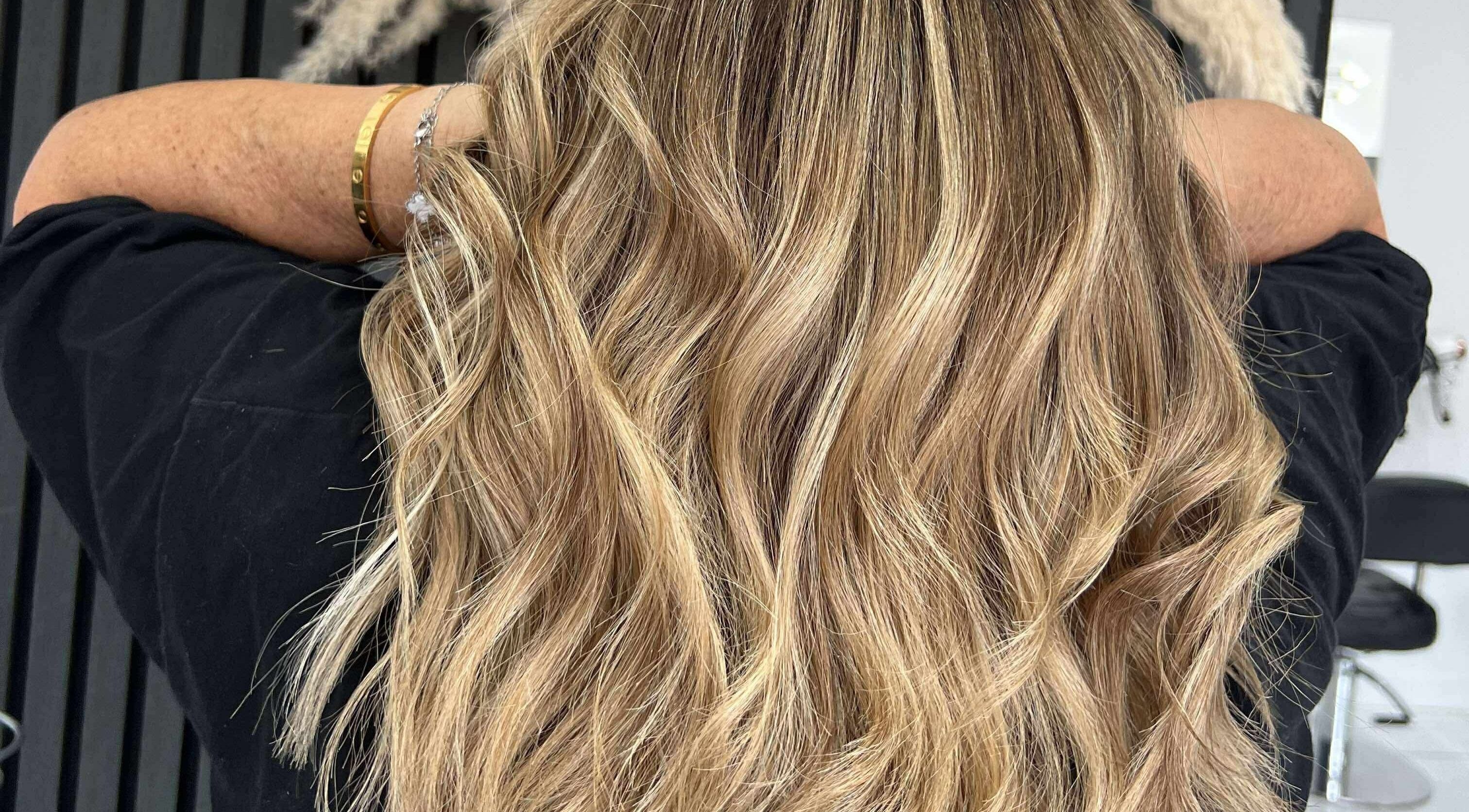 Blonde wavy hairstyle at KHD in Newtongrange, Scotland, GB showcasing vibrant highlights.