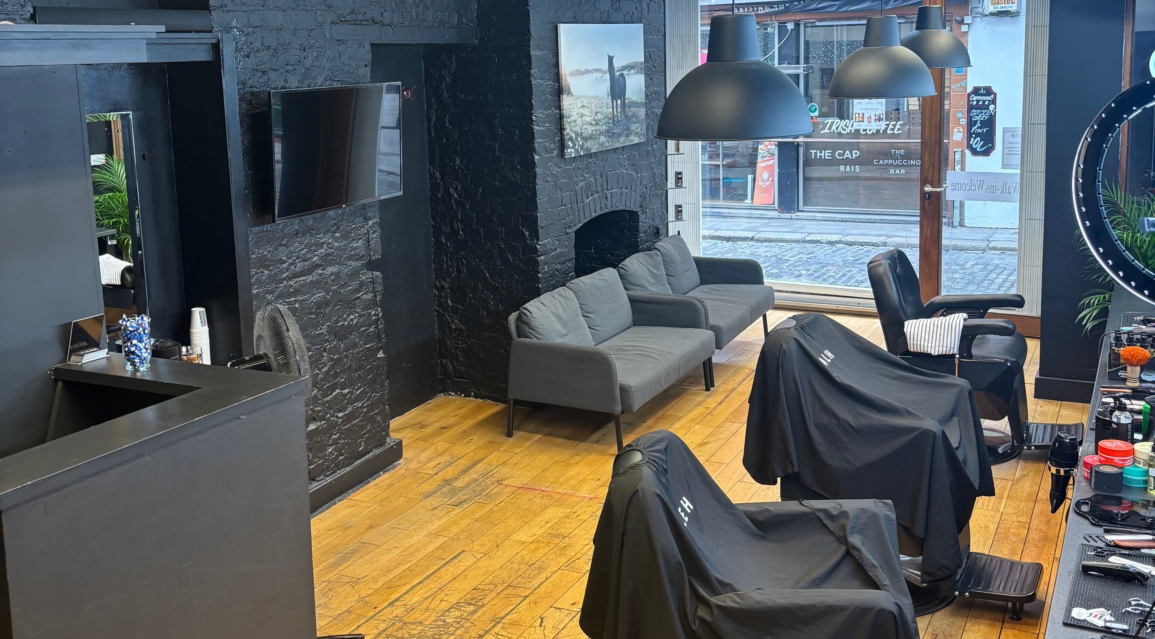 Interior do Valeh BarberShop em Dublin, IE, com cadeiras de barbeiro e decoração moderna.