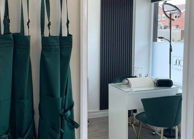Beauty treatment room at The Beauty Co., Rugby, England, GB featuring stylish aprons and a sleek nail station.