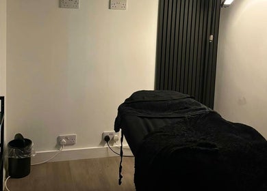 Peaceful treatment room at The Beauty Co., Rugby, England, GB, with a massage table and ambient lighting.