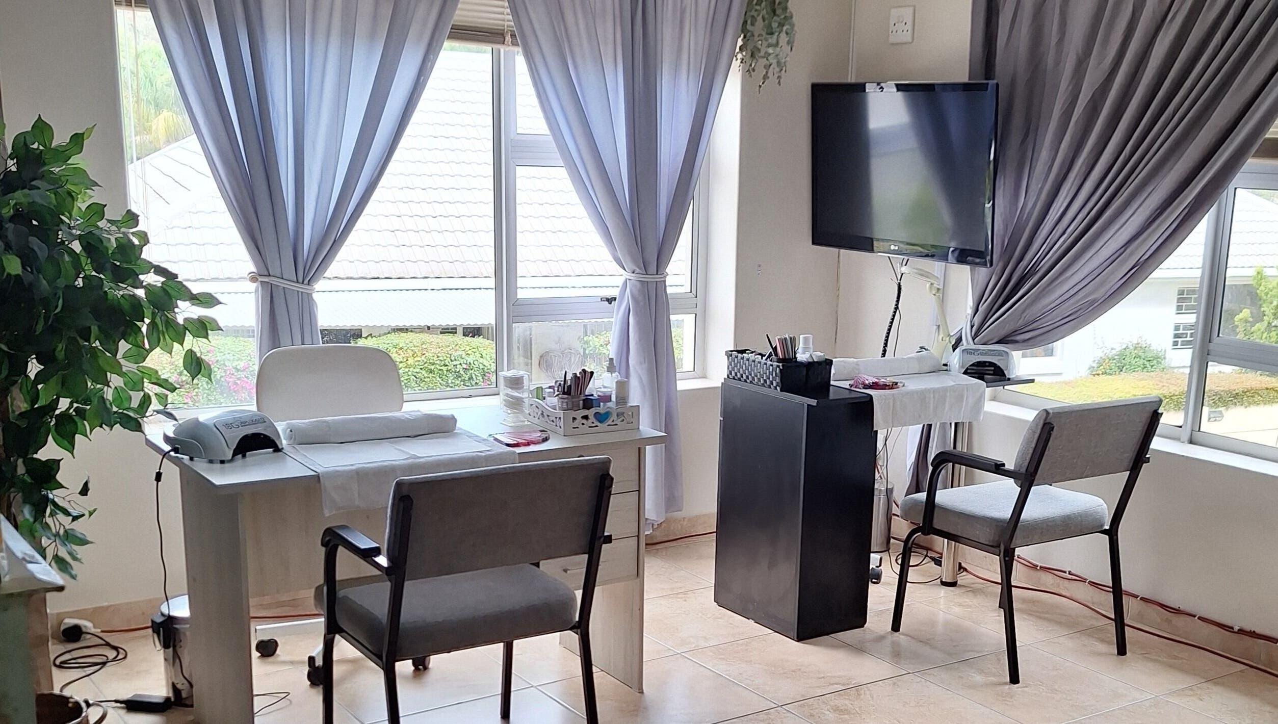 Bright interior of Arukah Skin & Beauty, Paarl, Western Cape, ZA, featuring a manicure station by large windows.