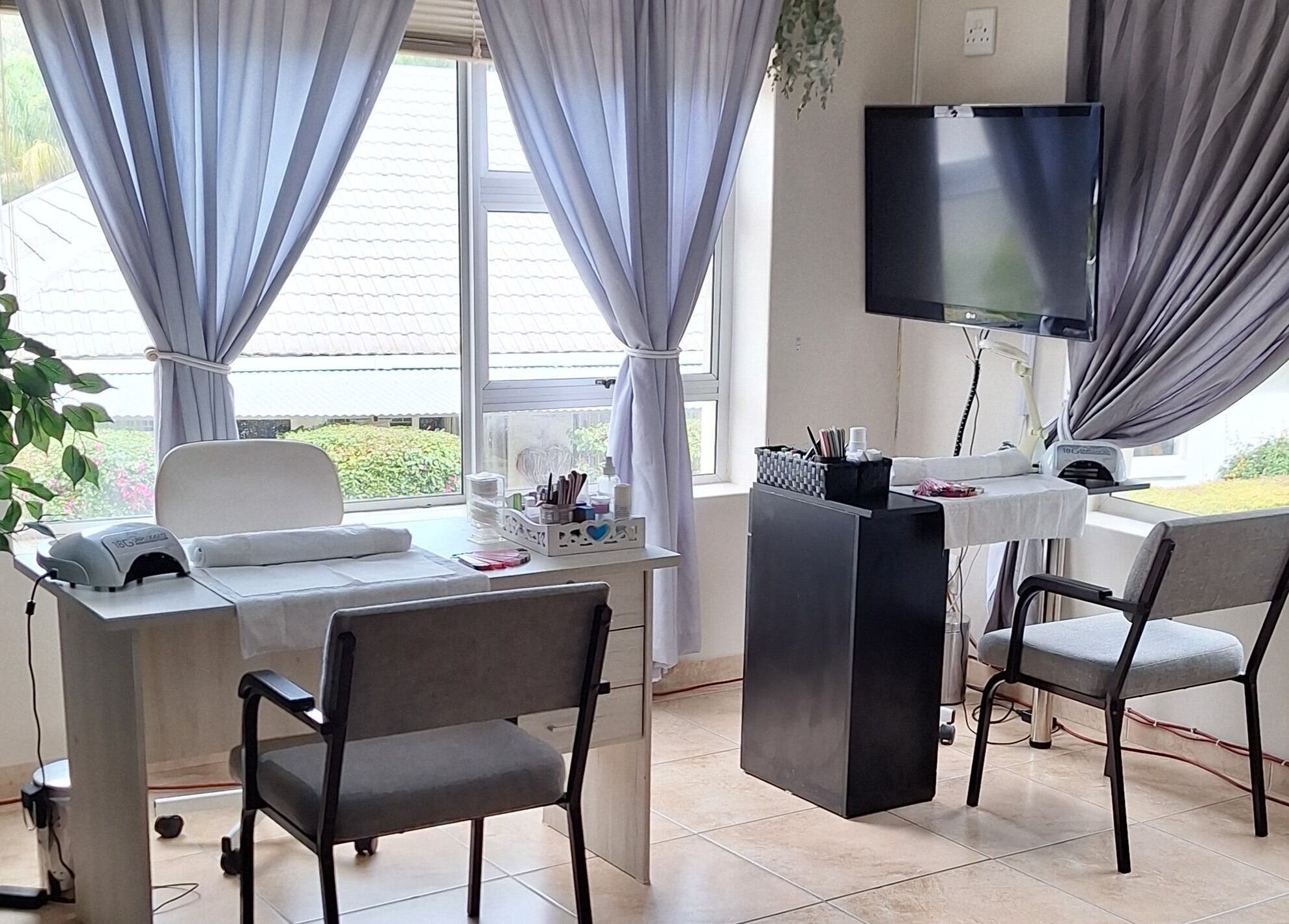Bright interior of Arukah Skin & Beauty, Paarl, Western Cape, ZA, featuring a manicure station by large windows.