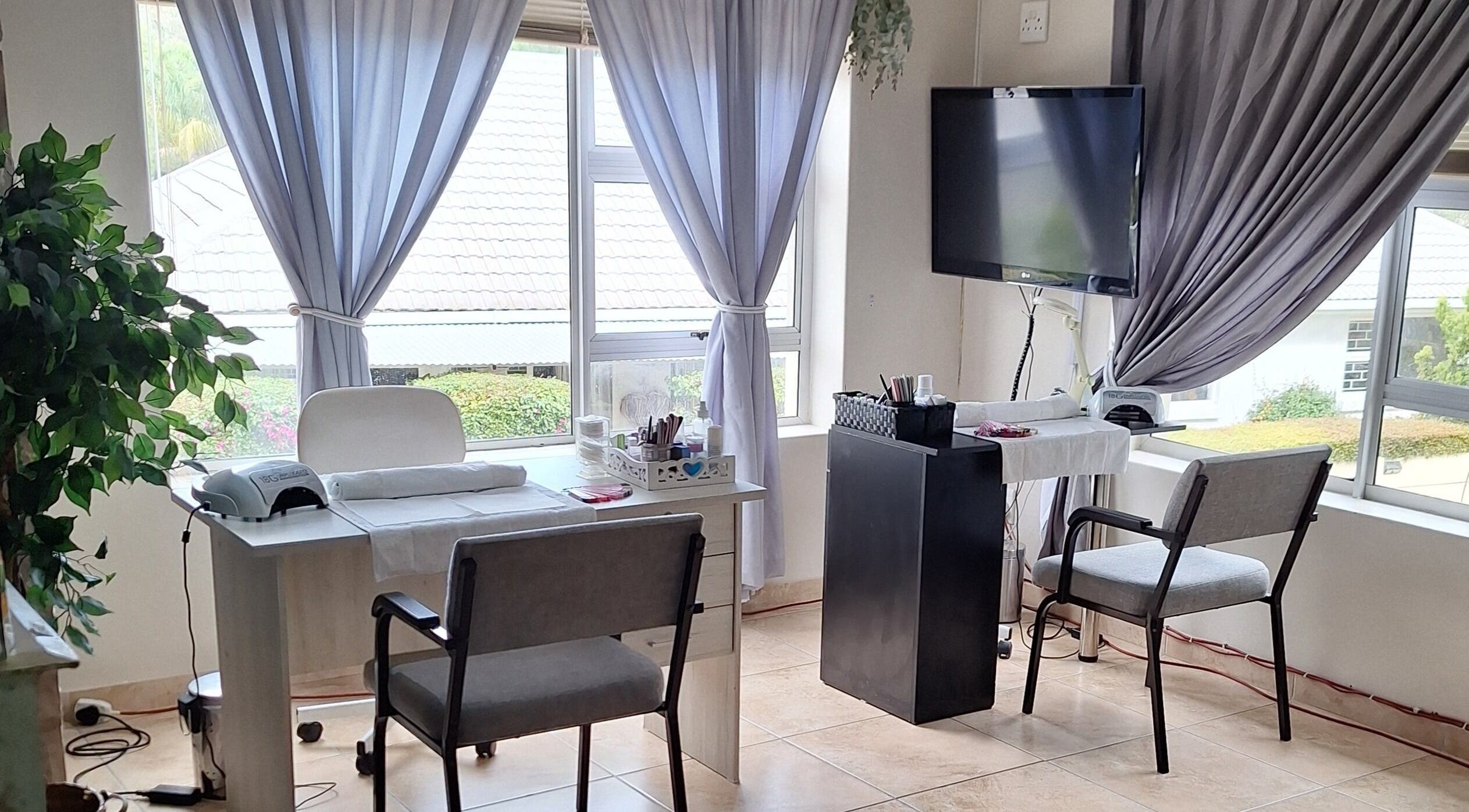 Bright interior of Arukah Skin & Beauty, Paarl, Western Cape, ZA, featuring a manicure station by large windows.