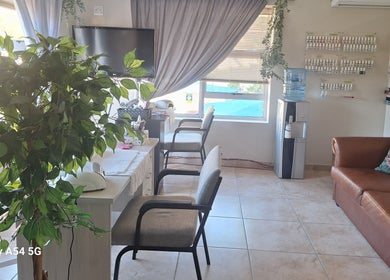 Relaxing interior of Arukah Skin & Beauty in Paarl, Western Cape, ZA with seating, decor, and nail polish display.