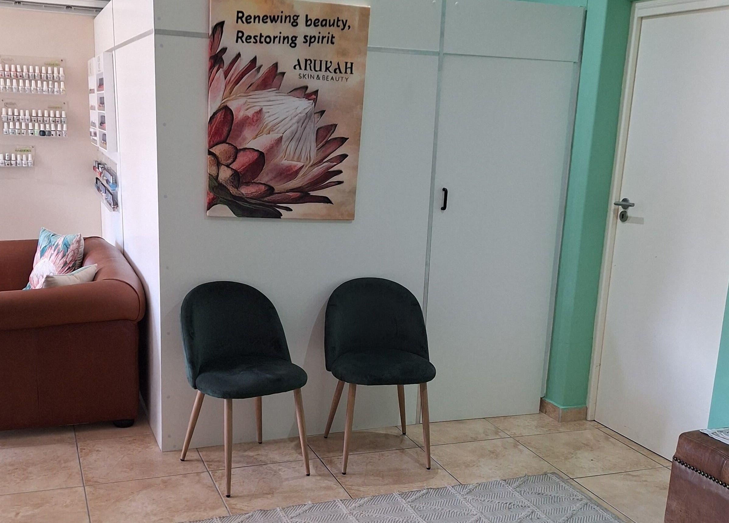 Inviting seating area at Arukah Skin & Beauty, Paarl, Western Cape, ZA with comfortable chairs and a floral poster.