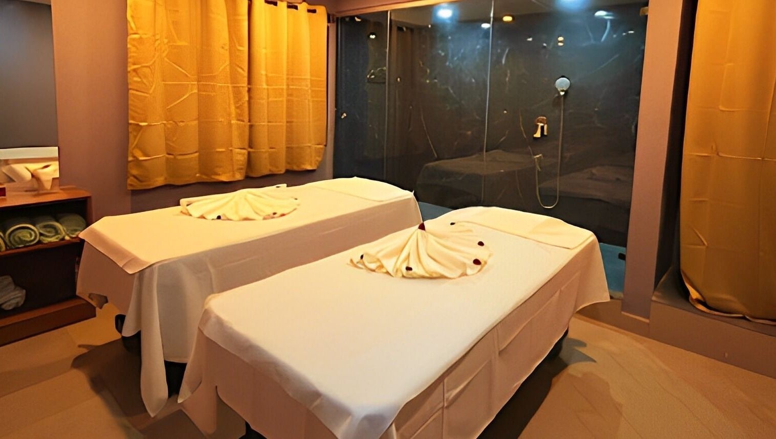 Relaxing treatment room at Ajna Spa, Bengaluru, Karnataka, IN, featuring two massage tables with elegant decor.